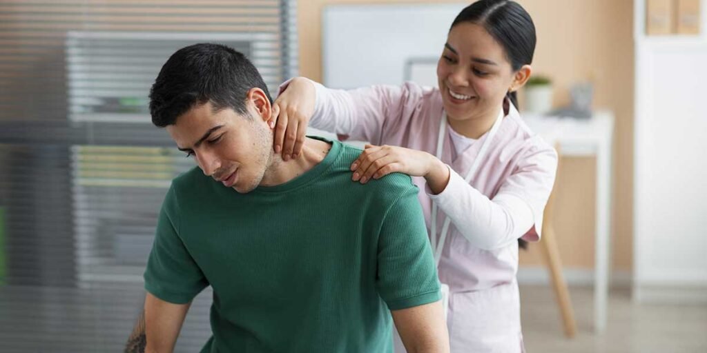 A smiling therapist performs massage therapy on a man's sore neck to help relieve painful pinched nerve tension and discomfort.