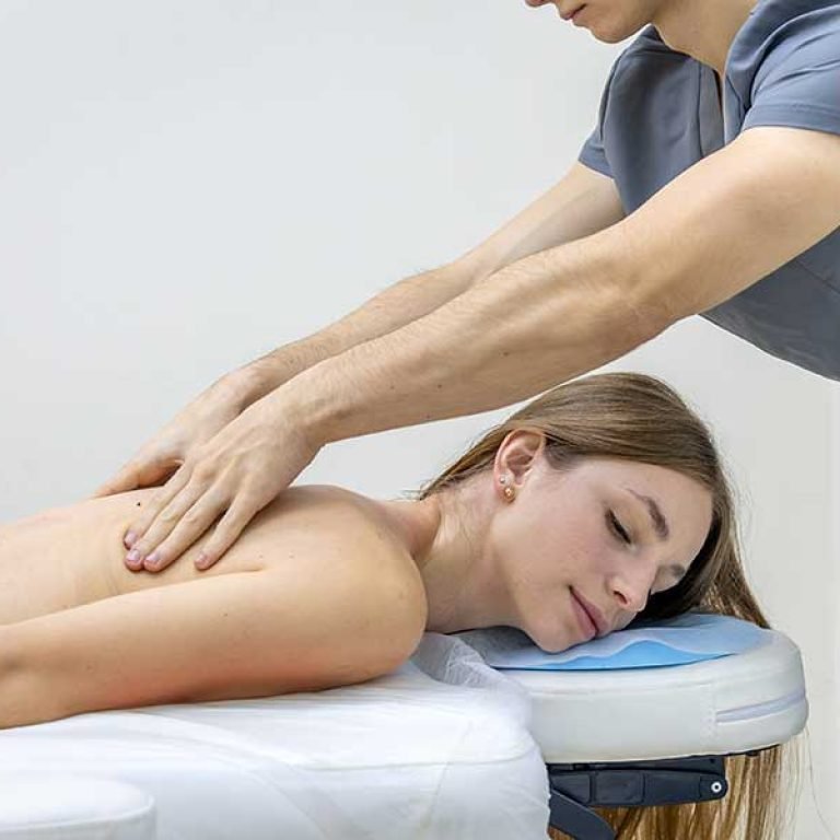 A therapist treats a woman's back, highlighting the choice between targeted rehabilitation physiotherapy and relaxing muscle massage therapy.